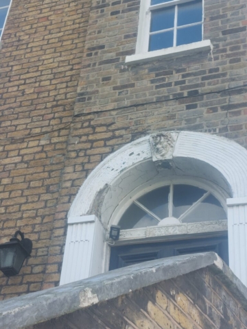 kennington green face face on a building above a door