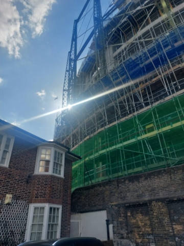 gasholder being developed, Oval gasholder by a suburban building