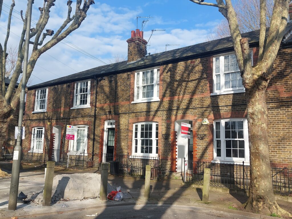 terrace of houses with sale signs