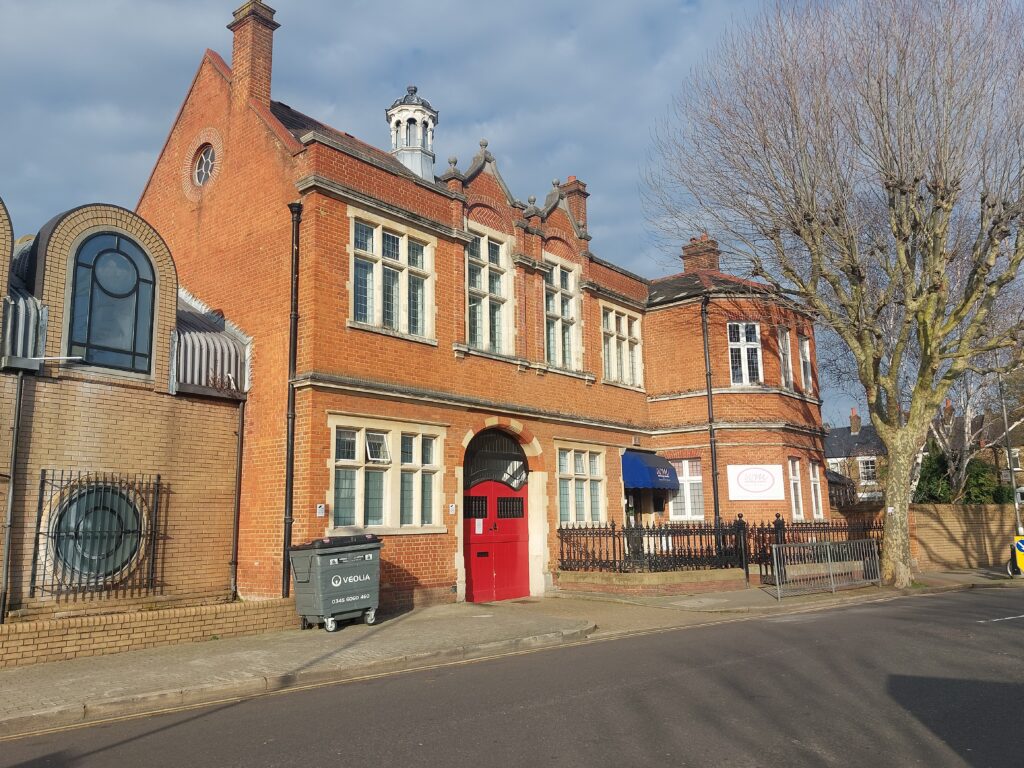 coroners court red brick buildings with a red door and a veolia grey bind on wheels and an 80s extension
